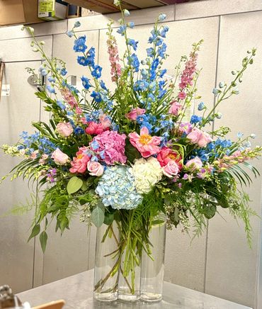 Elegant flower centerpiece with fresh roses and lilies in a white vase.