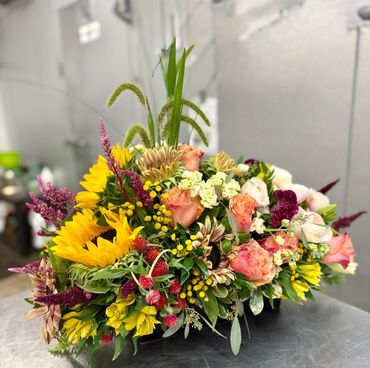 Romantic floral centerpiece in a white vase with pink roses and lilies.