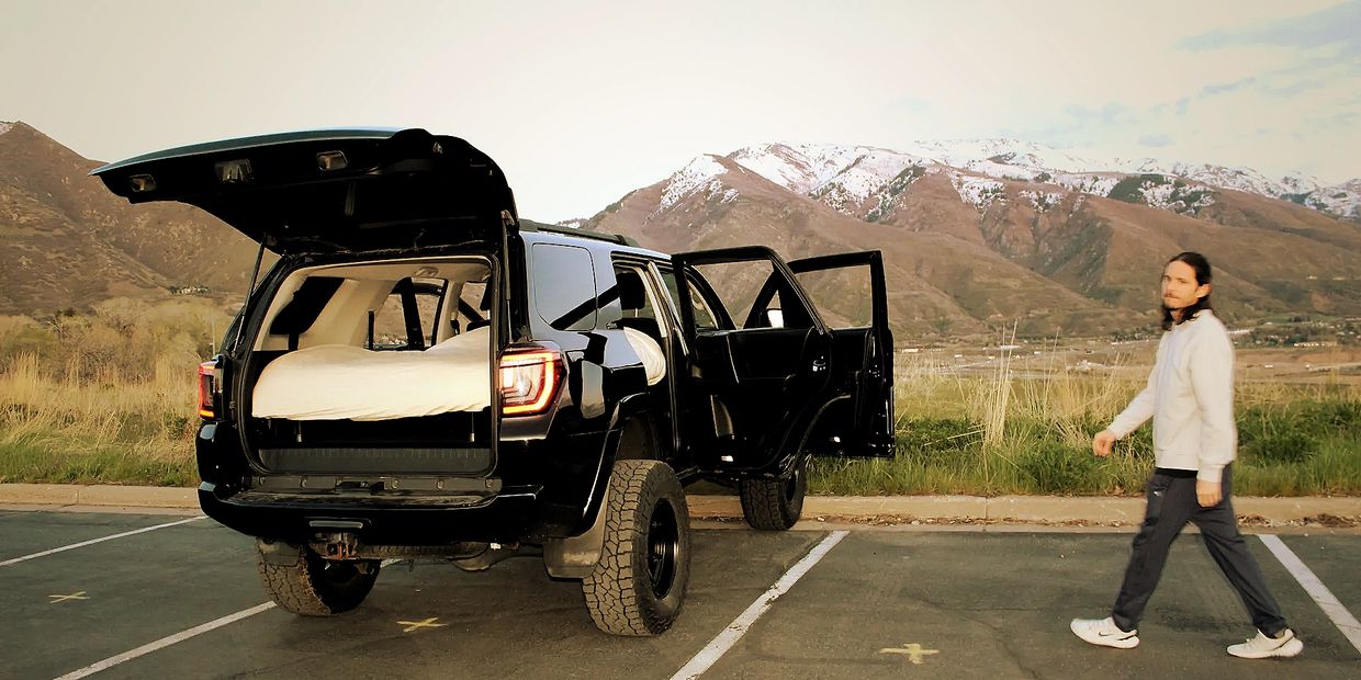 Man walking to overland car camping platform.