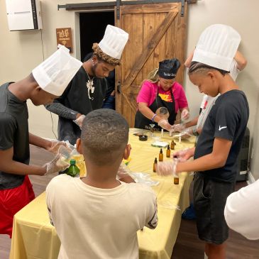 Children wearing chef hats engaging in a cooking or crafting activity.