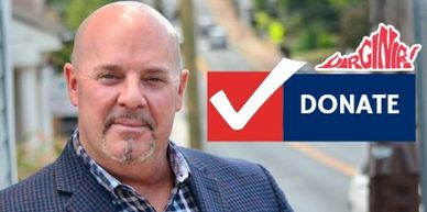 Man posing next to a Virginia-themed donate sign.