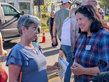 Paula Collins speaking to a voter in Lowville for the cream cheese festival. 