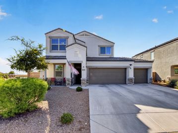 Modern two-story house with a three-car garage and desert landscaping.
