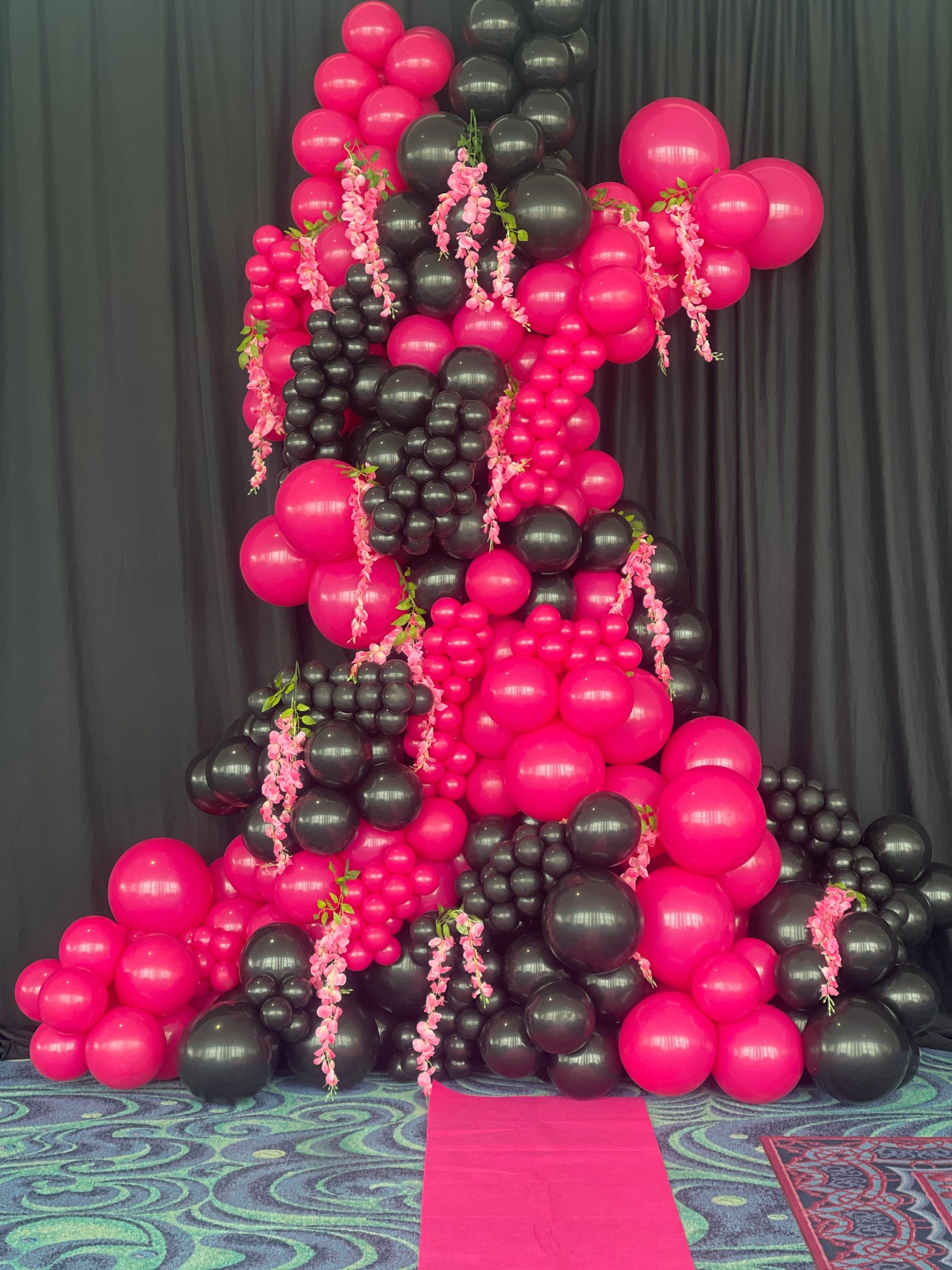 Balloons expertly arranged ceiling to floor balloon garland, a dramatic and memorable photo op area.