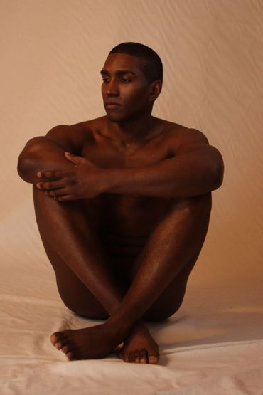 naked man sitting with crossed feet