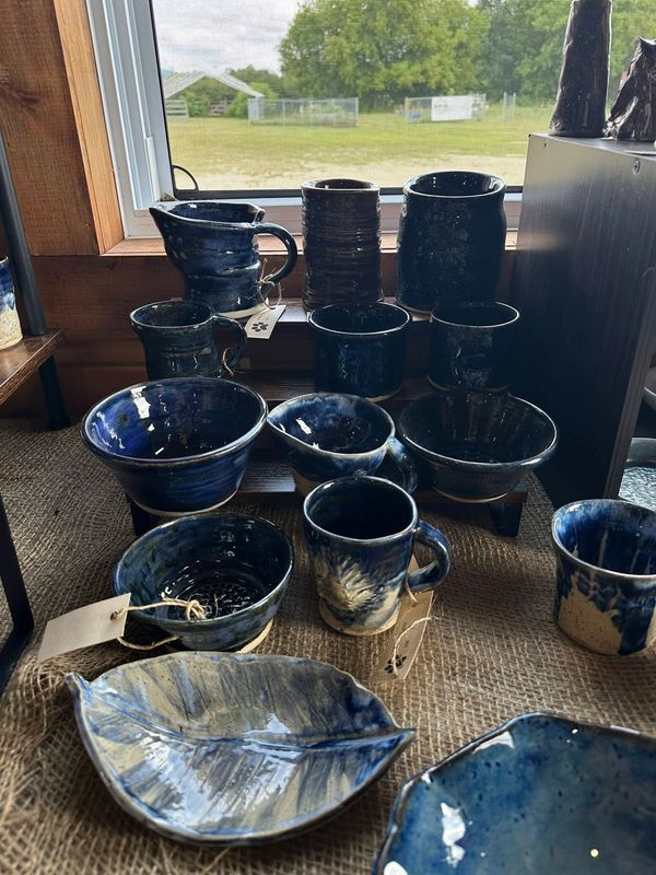 Handcrafted blue ceramic pottery displayed near a window with natural light.