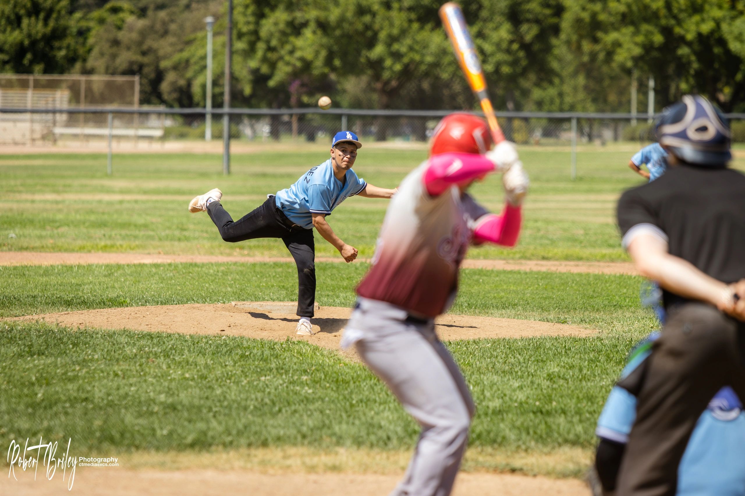 Baseball pitcher throwing ball to batter at bat.