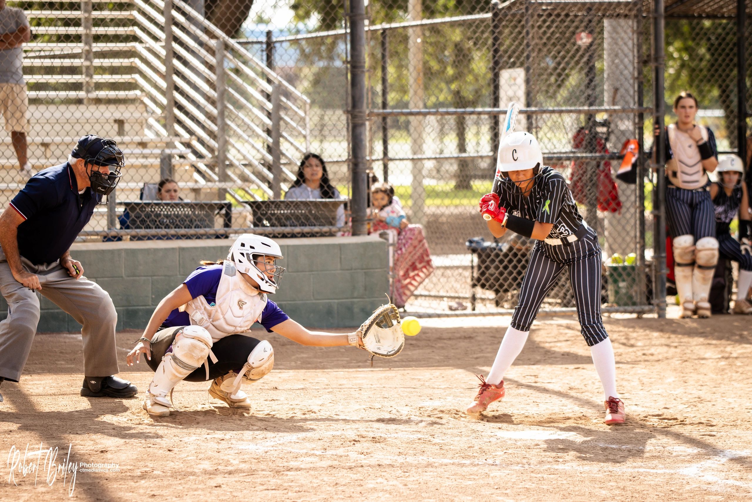 Softball player preparing to hit a pitched ball.