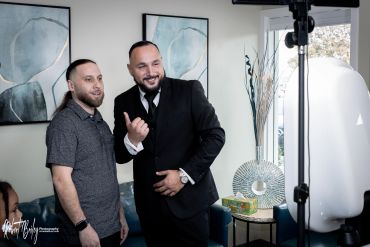 Two men posing for a photograph indoors.