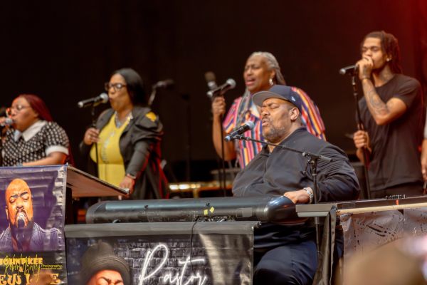 Group of five diverse singers performing on stage.