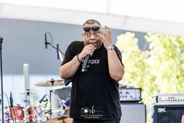 Comedian performing on stage with expressive gesture.