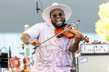 Musician passionately playing violin on stage.