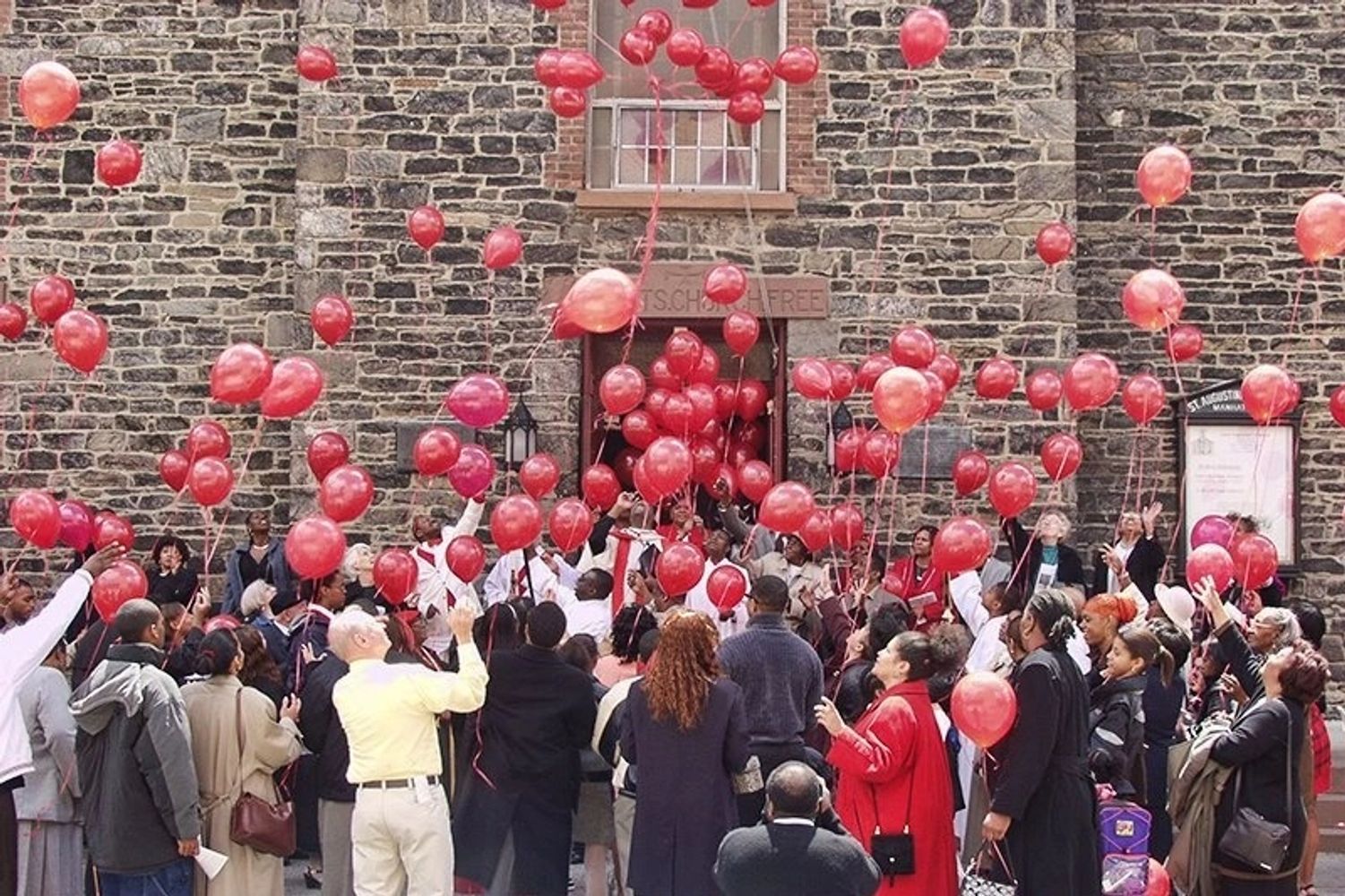 Parishioners standing outside in front of SAC to release red balloons for Pentecost.