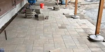 Paver patio professionally installed in residential yard, stones creating smooth, durable surface. 