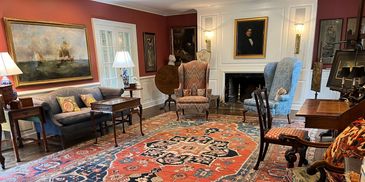 Elegant living room with antique furniture and large rug.