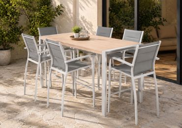 Modern outdoor dining set with six chairs around a wooden table on a stone patio.