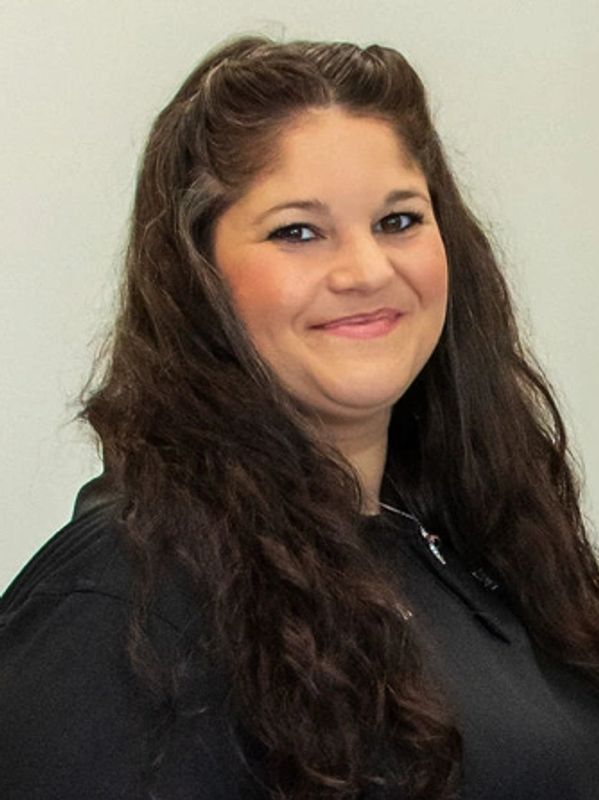 Smiling woman with long curly hair.