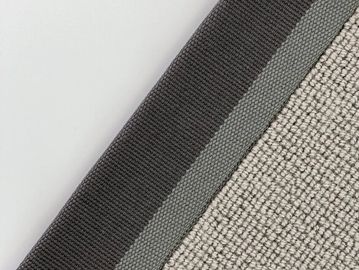 Close-up of fabric layers with textured and smooth materials in neutral tones.