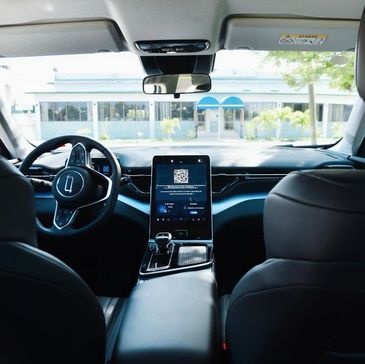 Interior view of a modern car with a digital touchscreen console and sleek design.