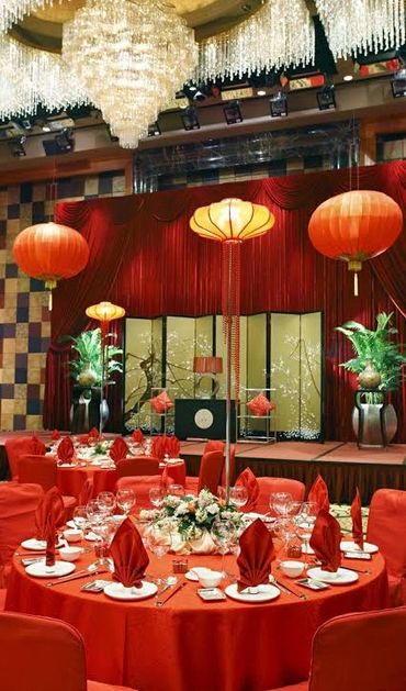 Elegant banquet hall decorated with red lanterns and table settings for a festive event.