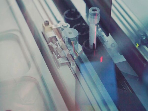 Close-up of a machine handling a test tube.