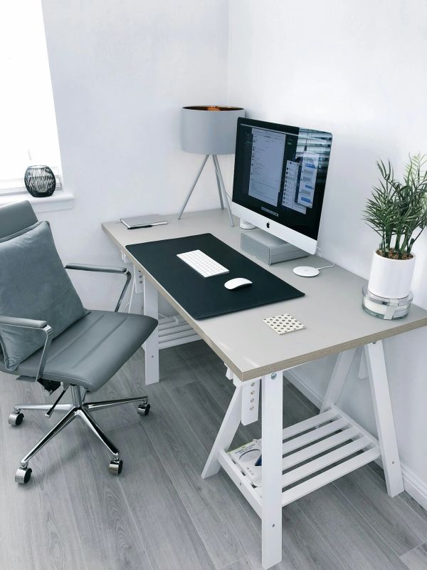 Minimalist workspace with large monitor and ergonomic chair.