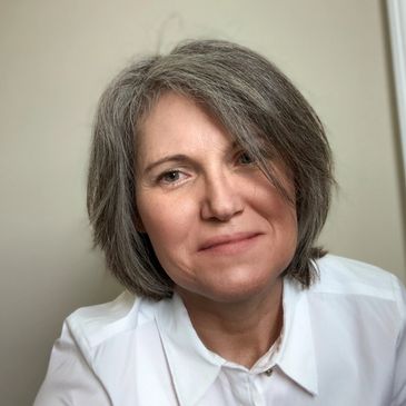 middle aged smiling woman with gray hair reading