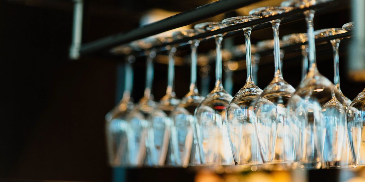 Rows of hanging wine glasses in a dimly lit bar.