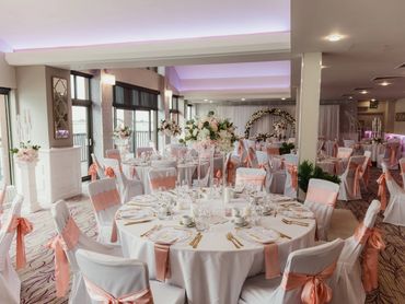 Elegant wedding reception with white and peach decor.