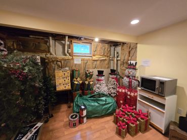 Holiday decorations and microwave in basement corner.