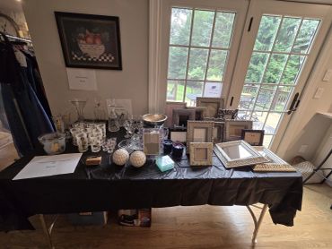 Table display with picture frames and glassware.