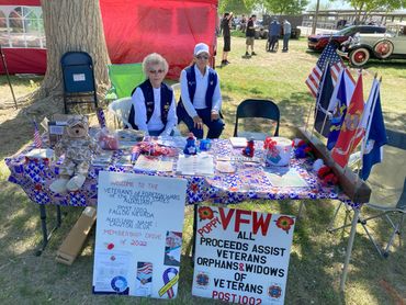 Two women at a Veterans of Foreign Wars membership drive booth with patriotic decorations.