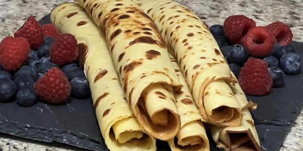 Rolled crepes with raspberries and blueberries.