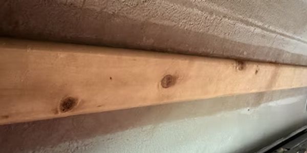 Wooden plank mounted on a wall.