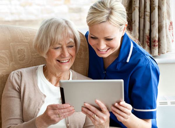 Carer and service user face-timing on a tablet.