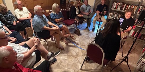 A group gathered for an intimate interview or discussion in a cozy room.