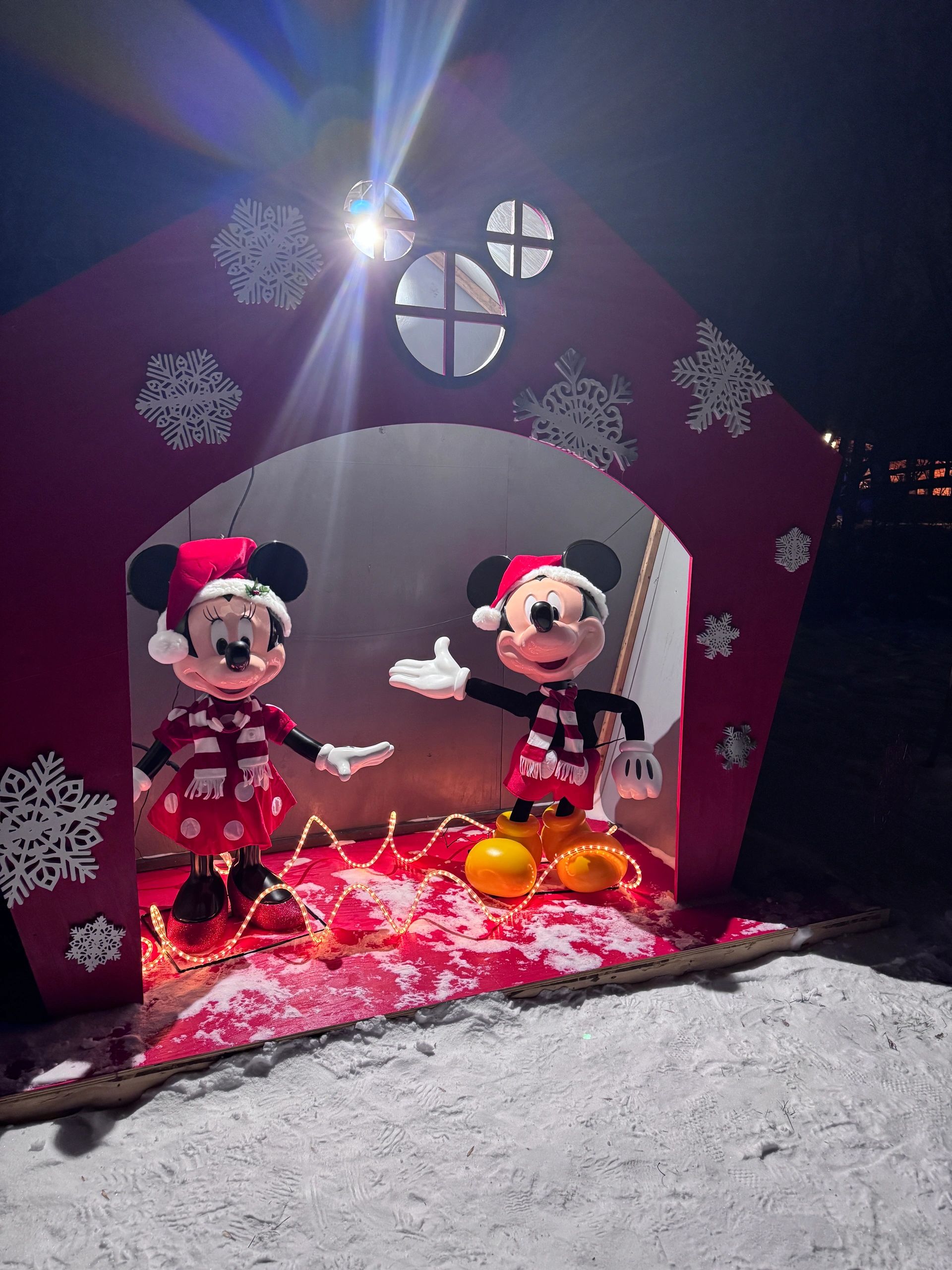 Holiday display with two cartoon mouse figures inside a red Christmas scene