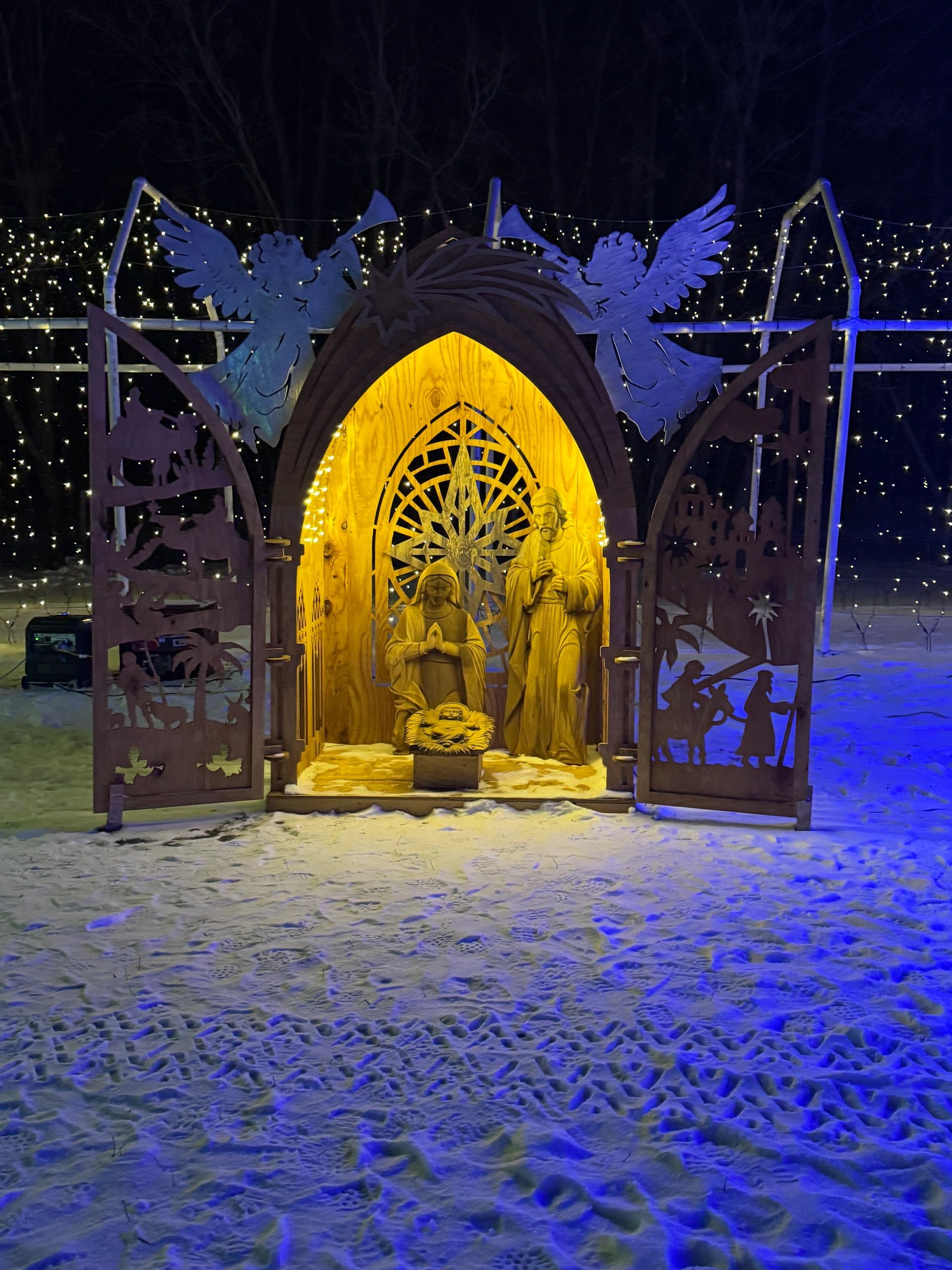 Lighted nativity scene surrounded by Christmas lights and snow at Romantic Moon