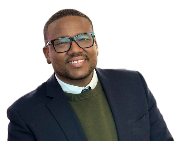 Smiling man in glasses wearing a suit and sweater.