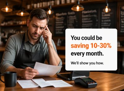 Man in a cafe reviewing bills with a savings message.