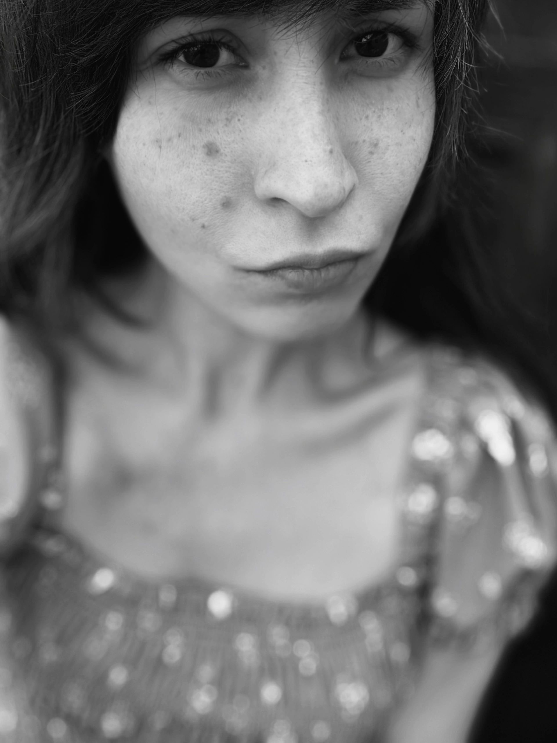 Black and white close-up of a woman's face with freckles.