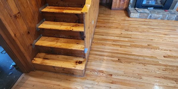 Rustic wooden staircase and polished hardwood floor in cozy cabin interior.
