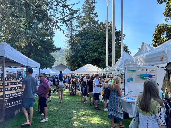 People peruse the artists booths on the lawn of the Civic Center on a beautiful September day.