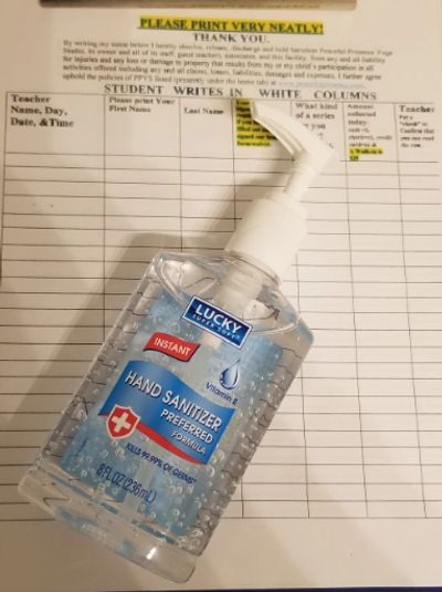 A bottle of Lucky Hand Sanitizer placed on a student health screening sheet.