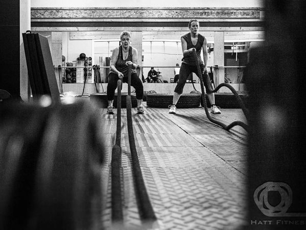 Two women using battle ropes.
