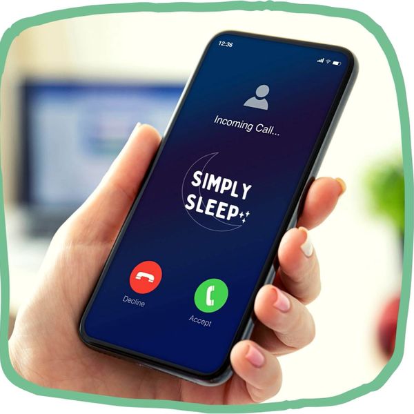 Hand holding phone with incoming call from Simply Sleep showing on scree