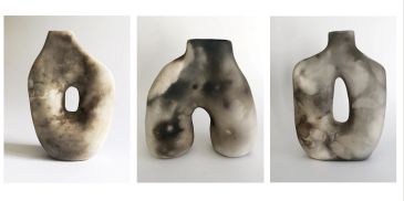Three abstract ceramic sculptures with organic shapes and smoky textures.