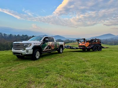 Truck and trailer hauling a remote controlled forestry mulcher 