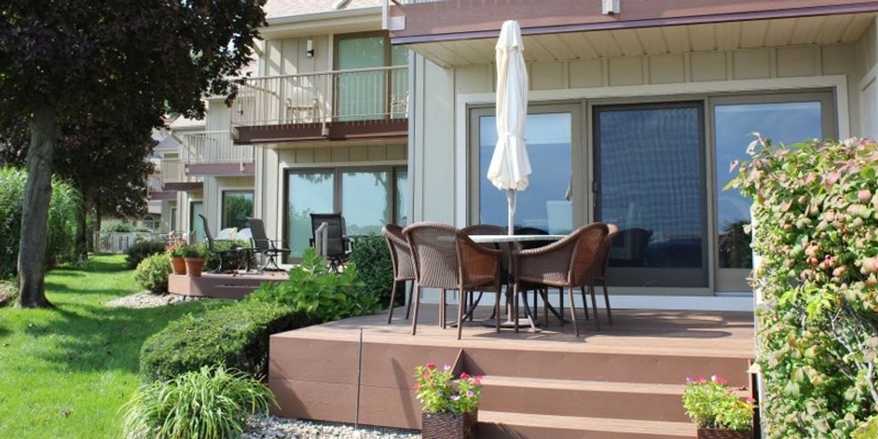 Cozy outdoor patio with table, chairs, and umbrella at a townhouse.