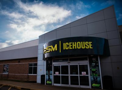 Entrance of PSM Icehouse with sports-themed posters on glass doors.